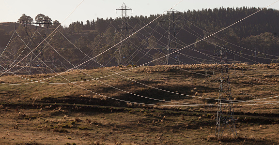 Electricity transmission towers crossing rural farmland, Tasmania, Australia