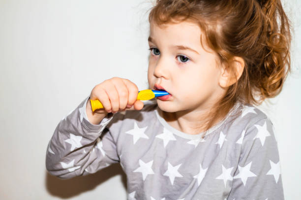 istock Young red head girl brushing teeth 1070955110