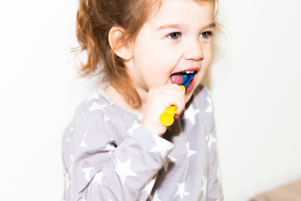 istock Young red head girl brushing teeth 1070955160