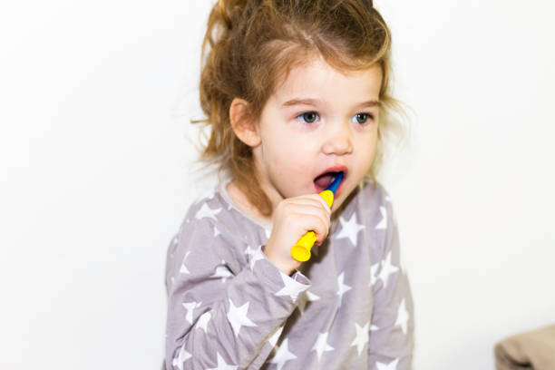 istock Young red head girl brushing teeth 1070955522