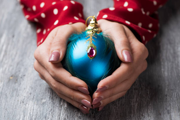 mujer con una bola de navidad adornados - ornamented accessory fotografías e imágenes de stock