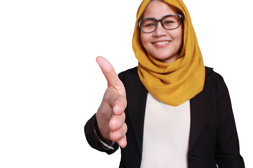 Asian muslimah businesswoman wearing glasses and suit with a friendly smile, want to shakes hand gesture. Isolated on white. Close up head and shoulders