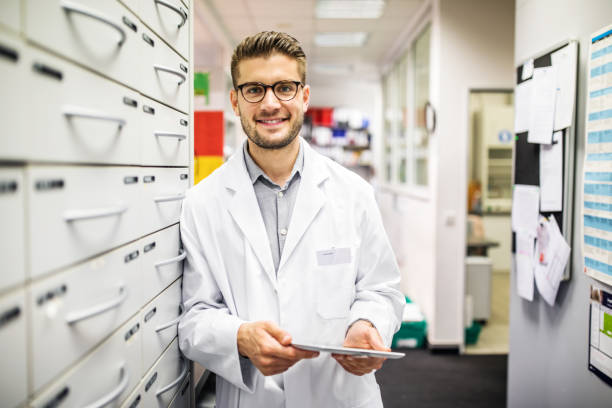 istock Confident chemist standing by a medicine shelf 1070962856