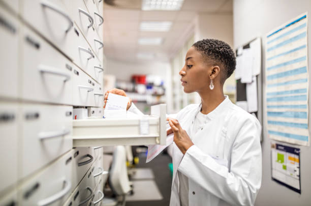 Female pharmacist looking for medicines in the rack