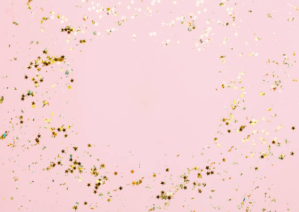 Pink confetti and stars and sparkles on pink background.