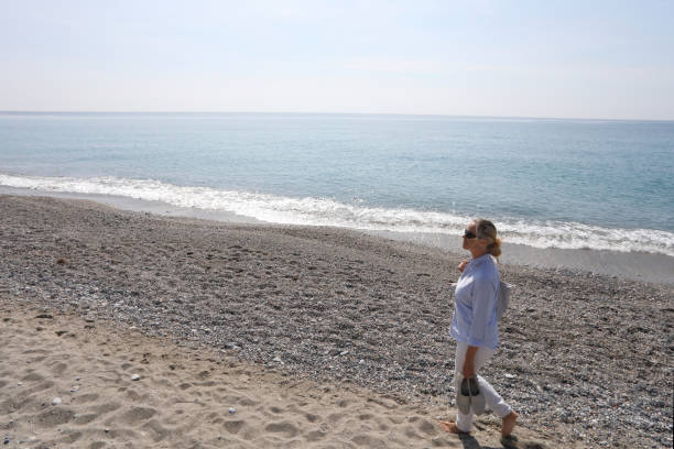 istock Woman walks along beach and sea 1070967832