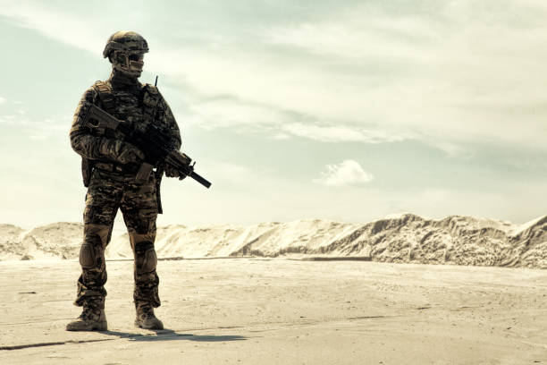 istock Equipped army soldier with rifle walks in desert 1070971010
