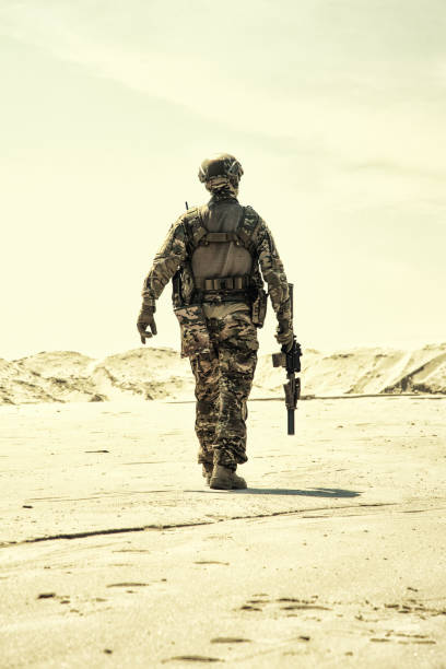 istock Army infantryman soldier with rifle desert patrolling 1070971060