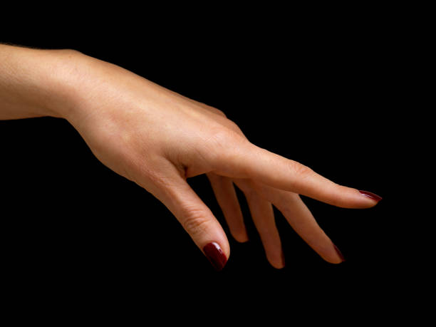 female hand with red nail polish on black background