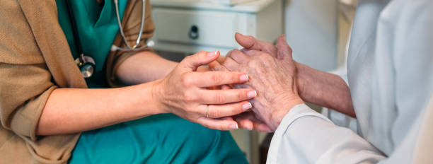 Doctor giving encouragement to elderly patient Female doctor giving encouragement to elderly patient by holding her hands hospice photos stock pictures, royalty-free photos & images
