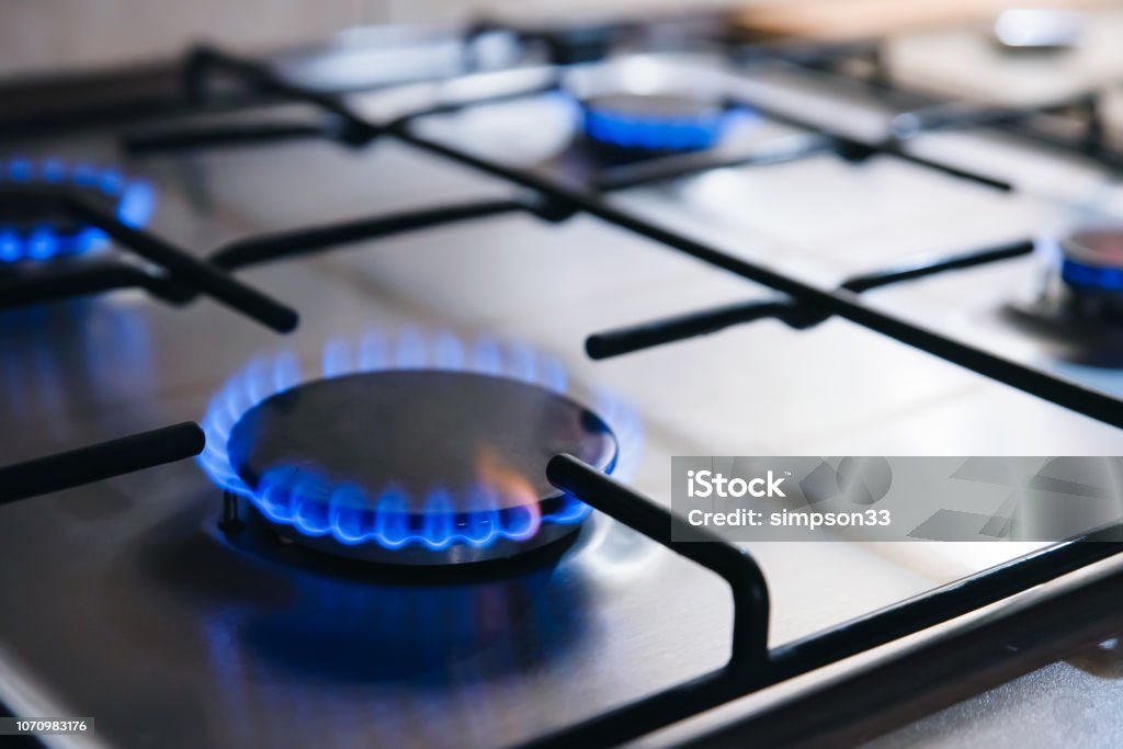 Gas kitchen stove cook with blue flames burning Gas kitchen stove cook with blue flames burning. Panel from steel with a gas Gas Stove Burner Stock Photo