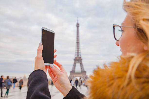 istock Girl using cellphone with Paris city background and Eiffel tower. 1070984266