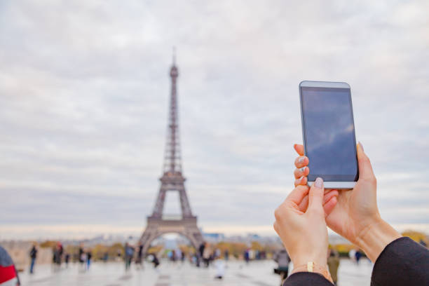 istock Girl using cellphone with Paris city background and Eiffel tower. 1070986934