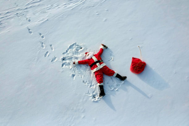 へべれけサンタ クロース雪の上に横たわる - santa claus gift snow sack ストックフォトと画像