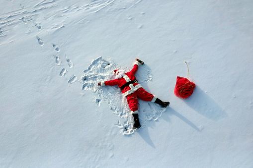 Drunk santa claus lying on the snow drone shot