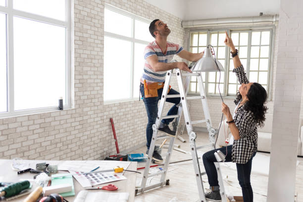 istock Couple making renovations, changing lighting equipment 1070987386