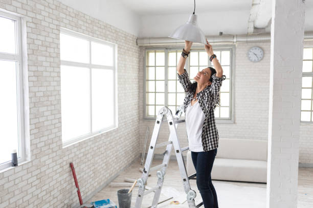 istock Woman making renovations, changing lighting equipment 1070987394