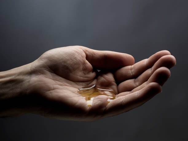 mano de hombre con aceite - aceite de masaje fotografías e imágenes de stock