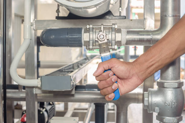 Hand opening stainless ball valve. Plumber hand opening stainless ball valve in the water treatment plant. Operation and Maintenance of Drinking Water System stock pictures, royalty-free photos & images