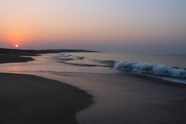 sonnenaufgang am morgen mit weißen gischt und wellen am strand - horizontal landscape coastline gujarat stock-fotos und bilder
