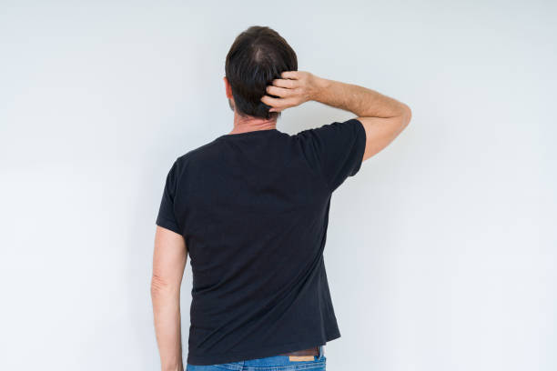 istock Senior man over isolated background Backwards thinking about doubt with hand on head 1070999432