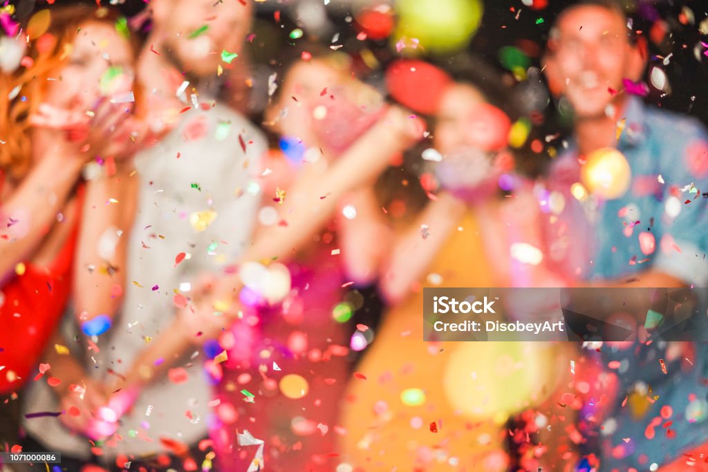 Partido haciendo borrosa de la gente tirando confeti - jóvenes celebrando el fin de semana noche - entretenimiento, diversión, fin de año, vida nocturna y fiesta concepto - desenfocada foto - Foto de stock de Celebración - Ocasión especial libre de derechos