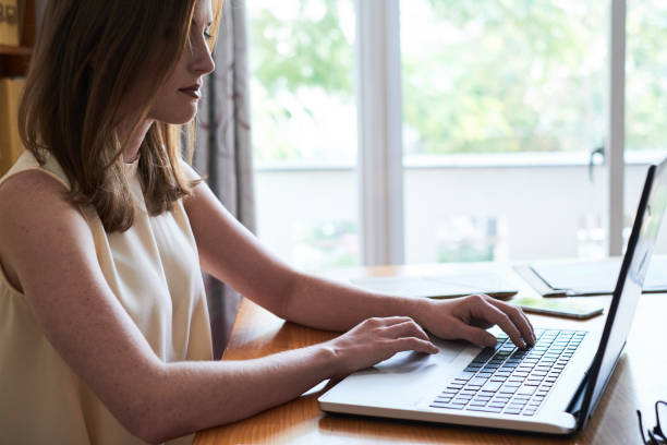 istock Casual young businesswoman using laptop in office 1071004126
