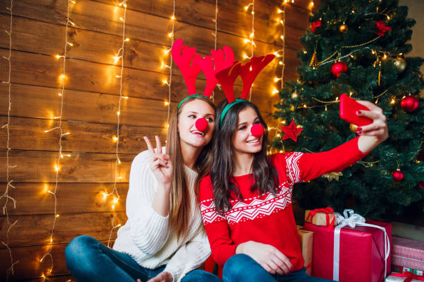 istock Smiling girlfriends taking a selfie with smarphone. Christmas mood. 1071006896