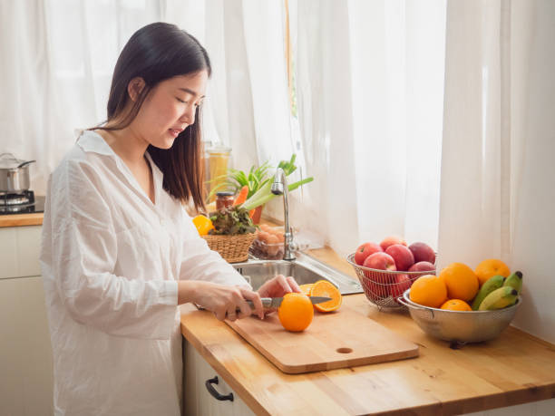 istock asian woman with fruit in the kitchen 1071010530