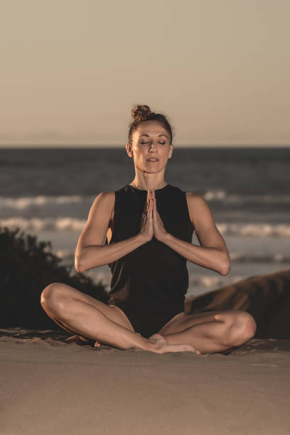 istock Woman in solitude on beach meditating 1071012224