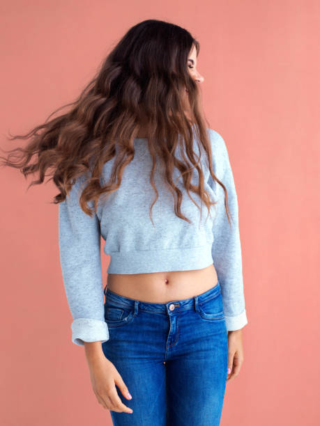 Studio shot of a beautiful young woman posing against a pink background