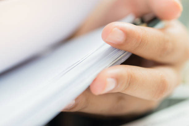 istock Accounting planning budget concept : Business woman offices working for arranging documents unfinished stack of document papers with pen, clip papers on busy office desk 1071014136