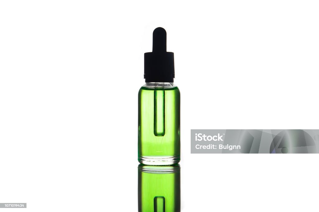 blank mock up advertising of the green e-liquid, e-juice in the bottle isolated on the white background with copy space (flacon with pipette) Electronic Cigarette Stock Photo