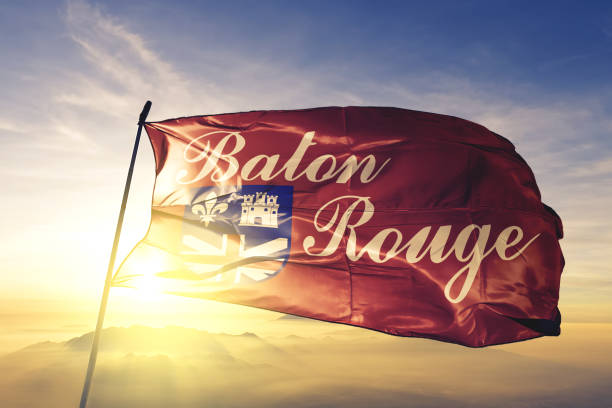 Baton Rouge city capital of Louisiana of United States flag textile cloth fabric waving on the top sunrise mist fog Baton Rouge city capital of Louisiana of United States flag on flagpole textile cloth fabric waving on the top sunrise mist fog baton rouge stock pictures, royalty-free photos & images