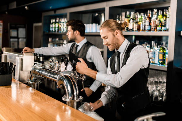 istock Handsome barman standing and working with coworker in bar 1071027236