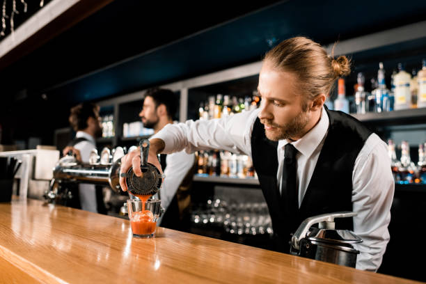 istock Barman pouring cocktail in glass on bar counter 1071027252