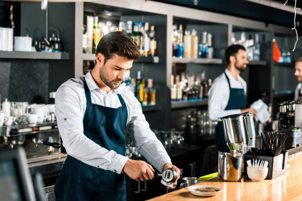 istock handsome barista preparing coffee at wooden counter 1071027352