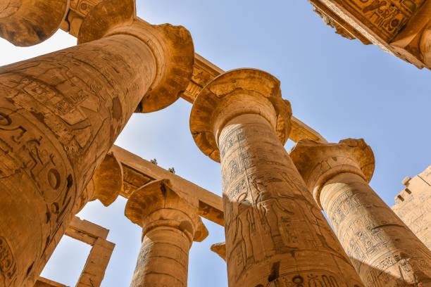 colonne e cielo blu nella grande sala ipostelio al tempio di amon-re a karnak - temple of luxor hypostyle hall foto e immagini stock