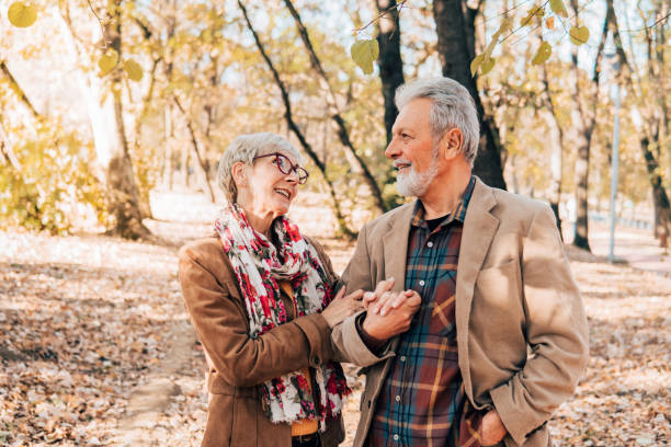 istock Senior couple romantically looking at each other in a park 1071034546