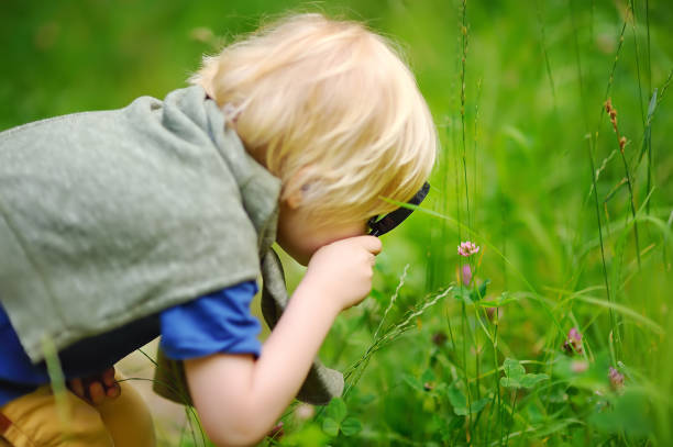 istock Charming kid exploring nature with magnifying glass 1071034744