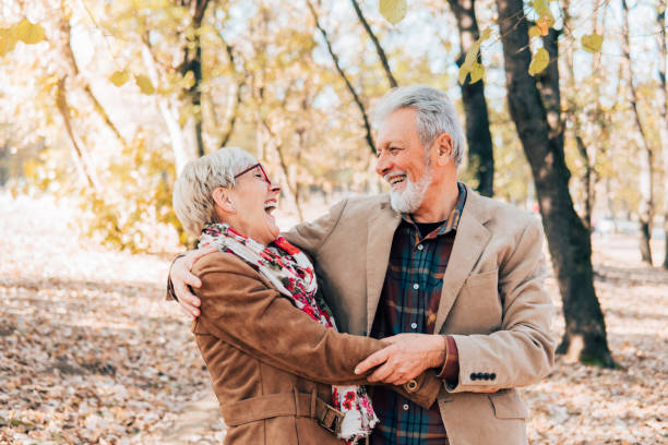 istock Senior couple laughing and hugging in a park 1071036088