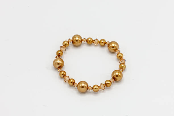 istock gold colored and multiple sized beads bracelet on white background 1071036602