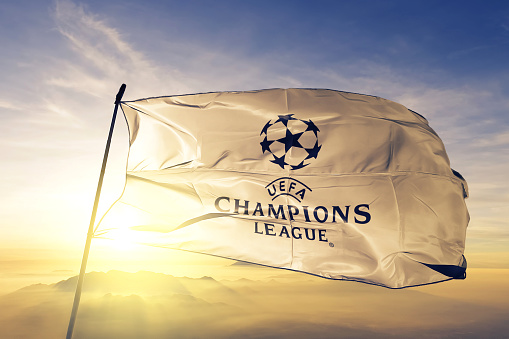 UEFA Champions League logo flag textile cloth fabric waving on the top sunrise mist fog