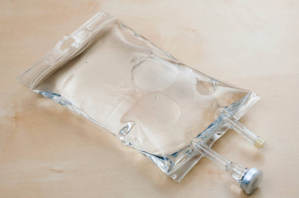 Saline bag on table Saline bag on table saline drip stock pictures, royalty-free photos & images