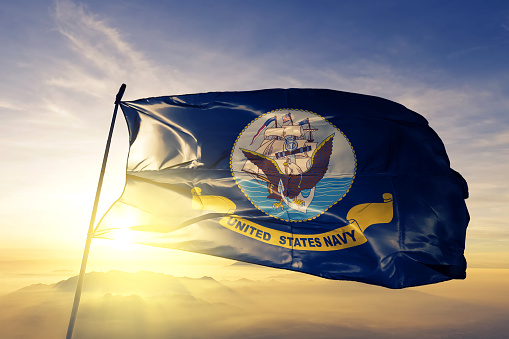 Marina de los Estados Unidos bandera tela tela ondeando en la niebla de la niebla de amanecer superior photo
