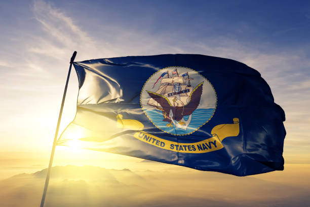 United States Navy flag textile cloth fabric waving on the top sunrise mist fog United States Navy flag on flagpole textile cloth fabric waving on the top sunrise mist fog us navy stock pictures, royalty-free photos & images