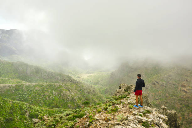 enjoying amazing view rear view of hiker man enjoying amazing view over Teno mountains. teno mountains photos stock pictures, royalty-free photos & images