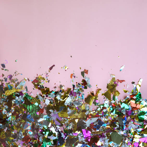 istock Bright colored confetti on pastel pink paper background. Frame copy space. Top view, flat lay. Holiday party concept 1071050034