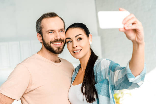istock beautiful smiling couple taking selfie on smartphone 1071052148
