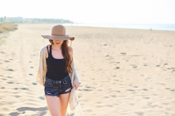 istock Beautiful young woman in straw hat on the beach 1071053210